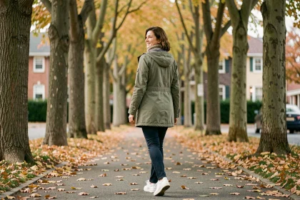 Femme de 40 ans marchant seule sur une allée arborée en automne, illustrant les bienfaits de la marche quotidienne sur le moral